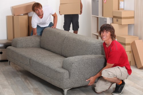 Professional movers carrying furniture from a flat in North London