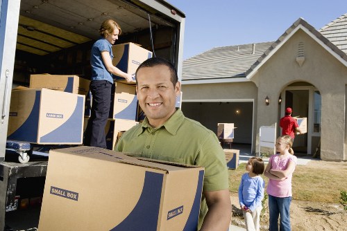 Professional movers carrying furniture in a London flat move